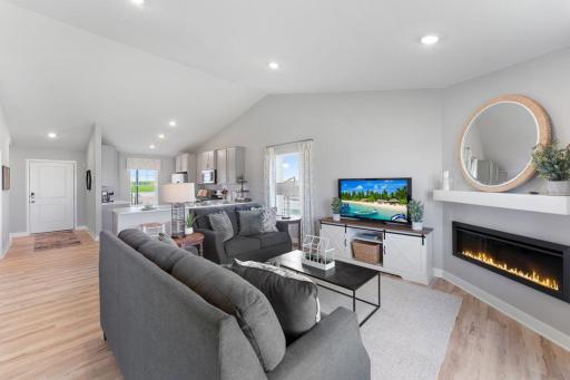 Open concept living with a modern electric fireplace. Our smart home package is included in every home. Photo is of actual home. Colors and options may vary. Ask Sales Agent for details.