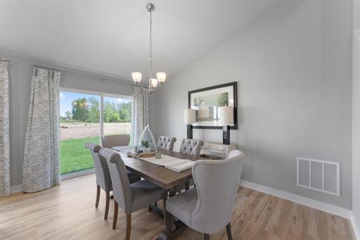 Bright light streams through the patio doors into the dining space. Photos of model home. Colors and options may vary. Ask Sales Agent for details.