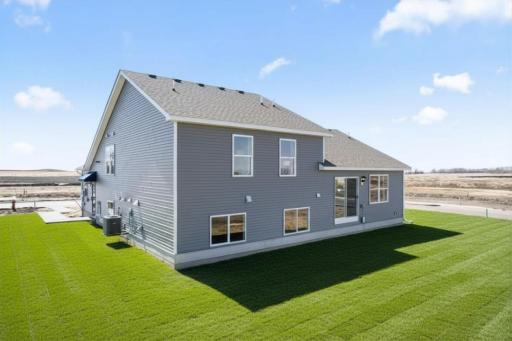 The Bryant II rear view at Highlands at Eagle View in Elko New Market. Photo is of a actual home. Options and colors may vary. Ask Sales Agent for details. AI-generated landscaping for visualization. Actual yard condition may differ.