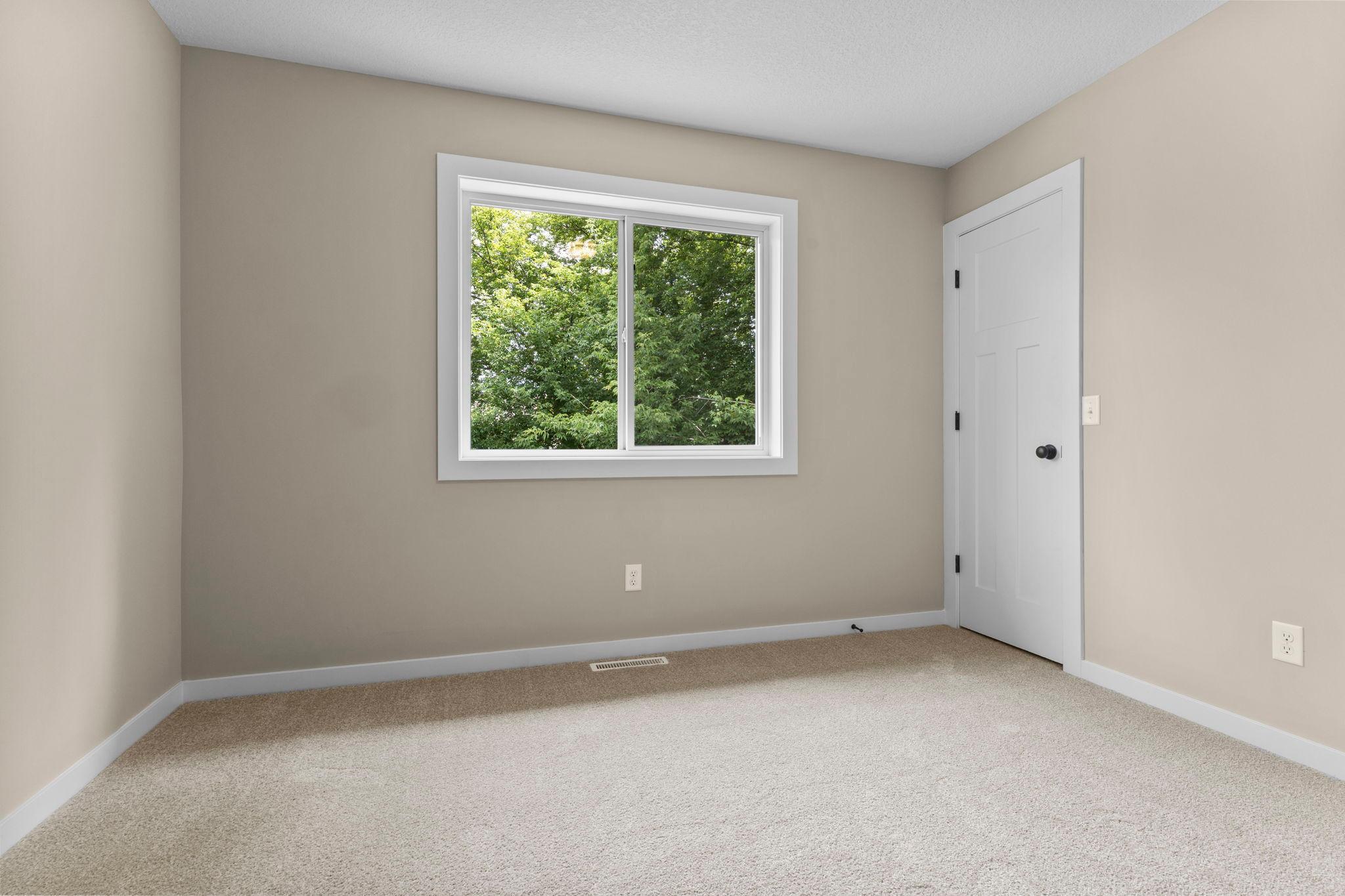 Upper-Level Bedroom #1: Bright and inviting, this bedroom features large windows that fill the space with natural light, generous closet space, and updated finishes, creating a comfortable and relaxing retreat.