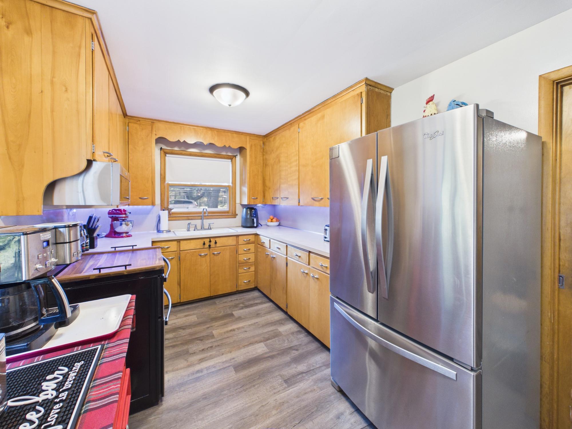 Kitchen view featuring the stainless steel refrigerator, extensive cabinetry and convenient U-shaped workspace.