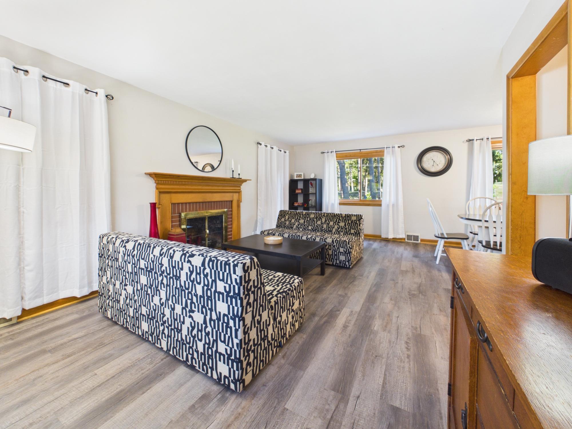 Wide view of the main level showing the living room, fireplace and adjoining dining area.