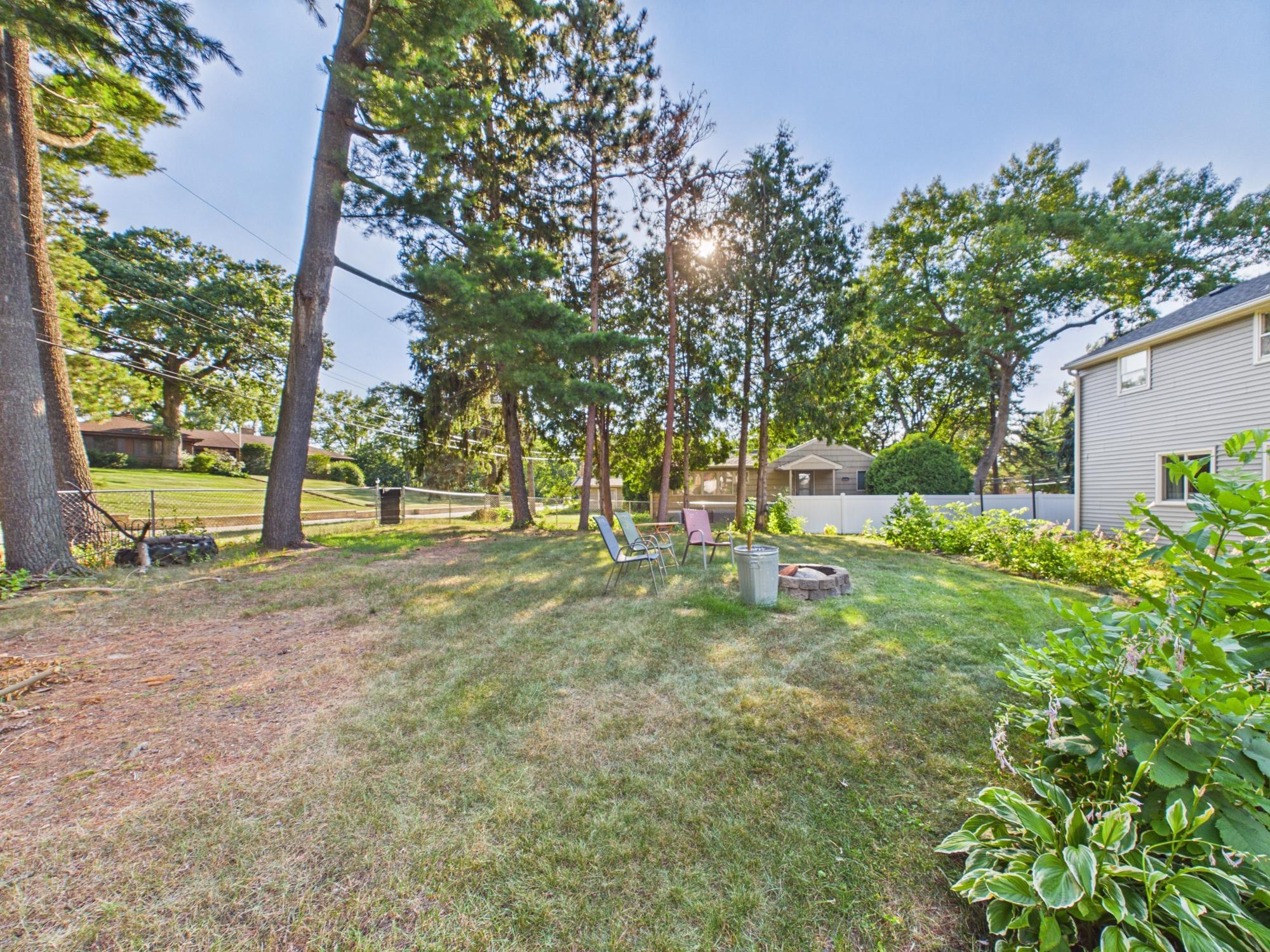 A first look at the exceptionally large backyard, surrounded by mature trees with plenty of space for outdoor living and play.