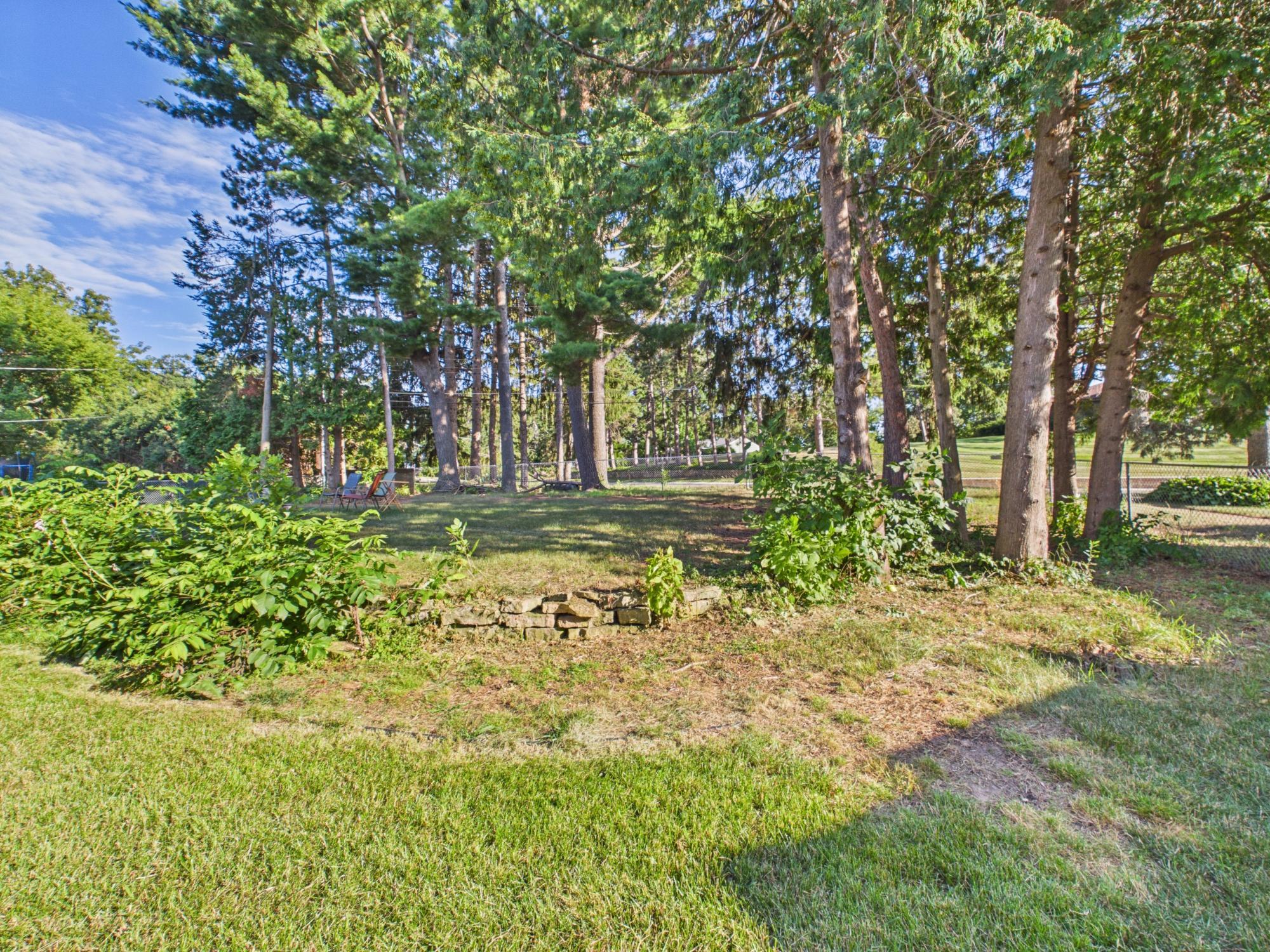 Mature trees and established landscaping provide shade and character throughout the backyard.
