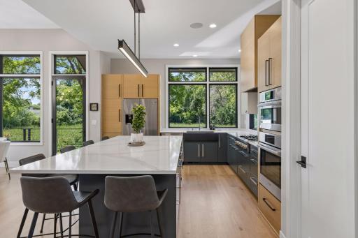Designed for entertaining, this contemporary kitchen showcases a large island, designer lighting, and an open, functional layout