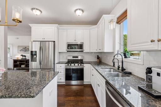 A spacious center island anchors this chef-inspired kitchen, offering additional seating, prep space, and storage. Stainless steel appliances and quality finishes complete this beautifully designed space.