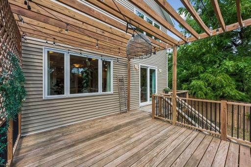 The expansive deck with its custom pergola provides the perfect backdrop for outdoor dining, morning coffee, or evening gatherings under the string lights.