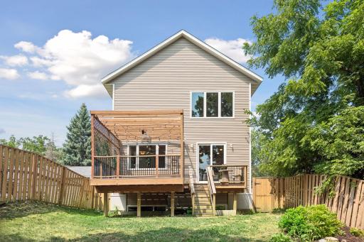 The backyard is complemented by an impressive rear elevation featuring a large deck, pergola, and easy access to both indoor and outdoor living spaces.