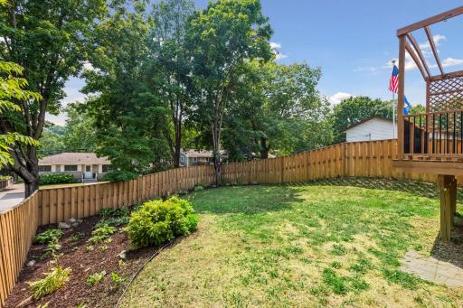 Step outside to a fully fenced backyard surrounded by mature trees, offering privacy and plenty of space to play, garden, or simply relax.