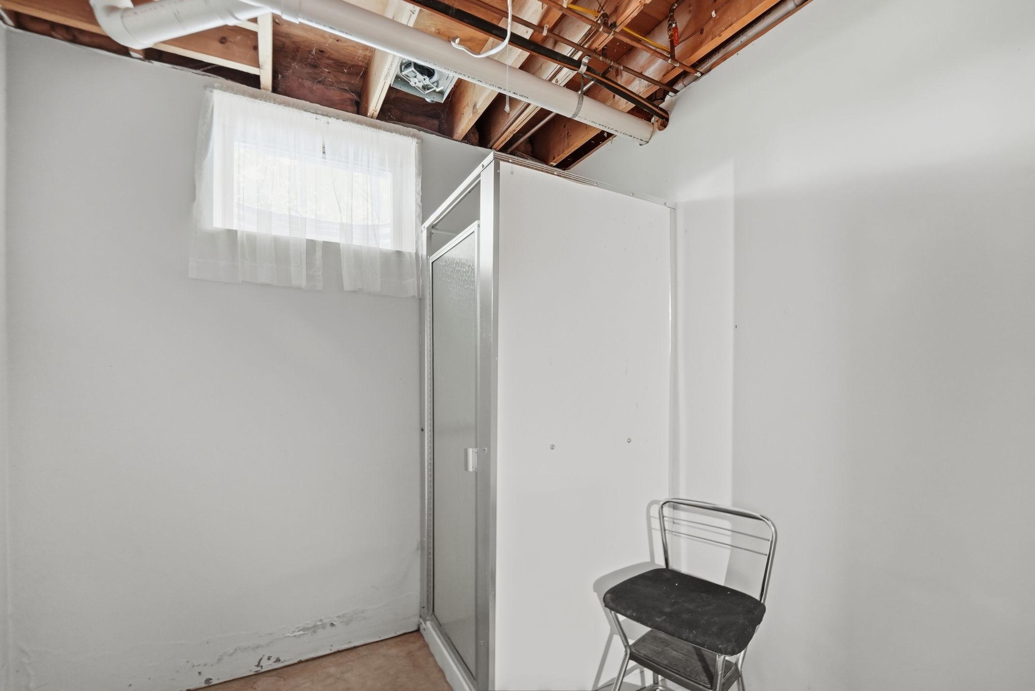 Lower level bath has a shower and plumbing for a sink and toilet roughed in