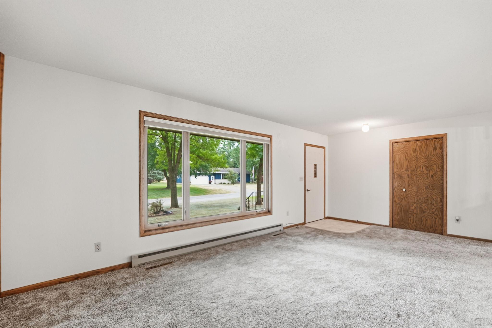 The living room is filled with natural light from the large front windows