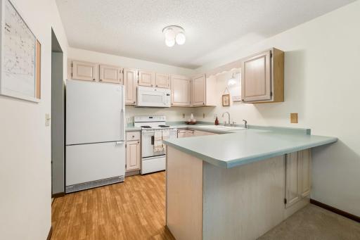 Wrap around cabinetry, convenient peninsula with bar seating, and abundant storage are the highlights of this kitchen.