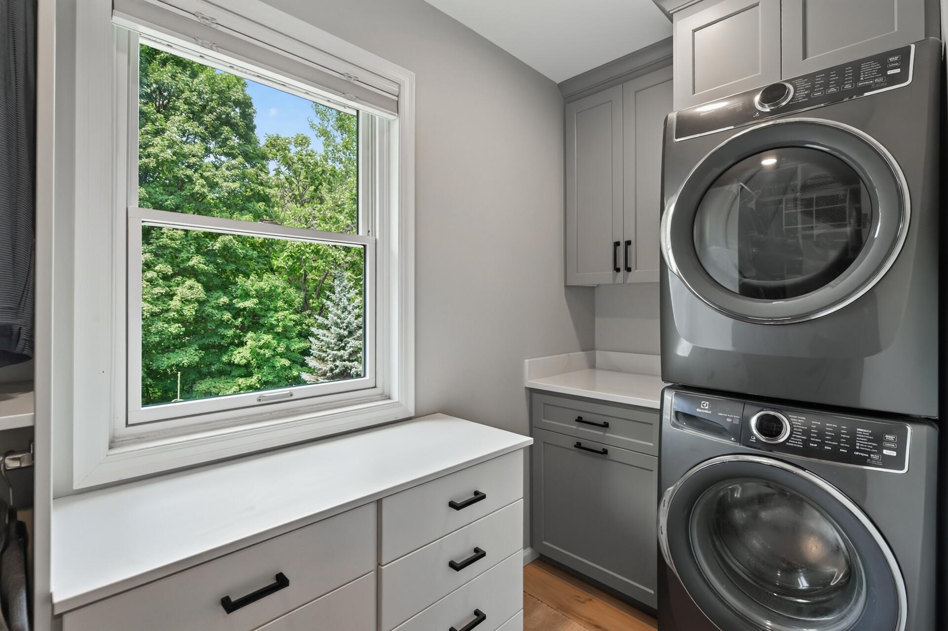 Walk-in custom closet organization, a convenient stacked washer and dryer