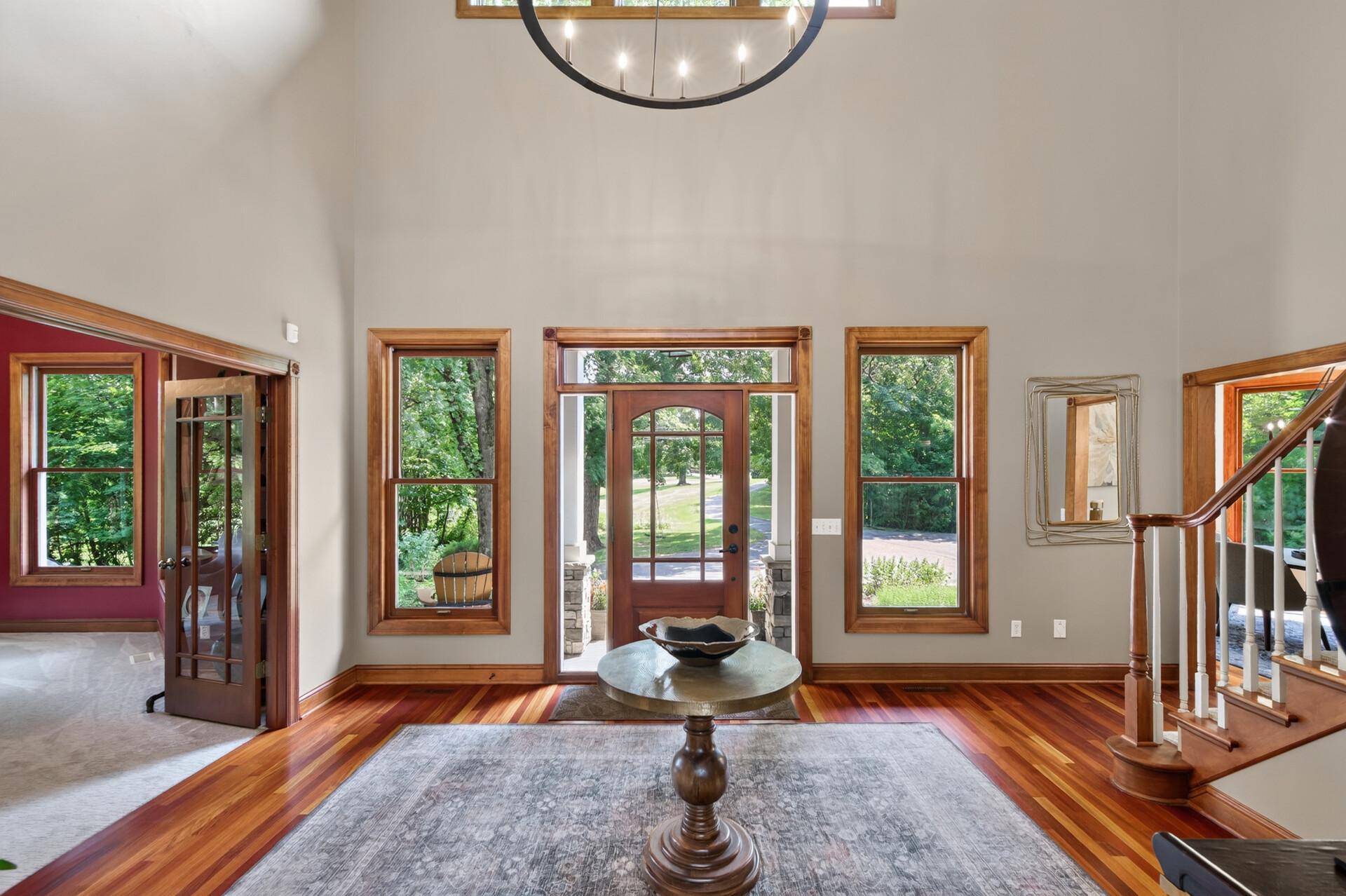 Grand foyer with soaring ceilings and oversized windows, creating a light-filled, bright, and airy first impression