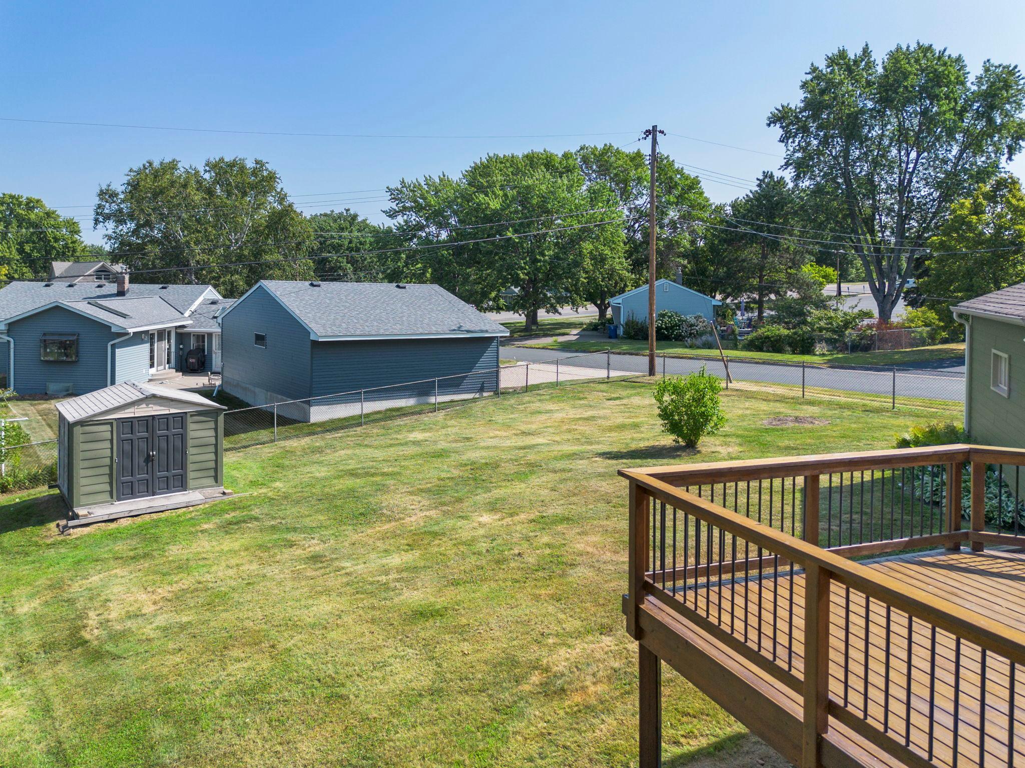 Spacious fully fenced back yard featuring a storage shed.