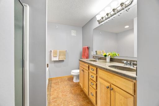 Double vanity, tile floor, separate tub and shower in ensuite bathroom.