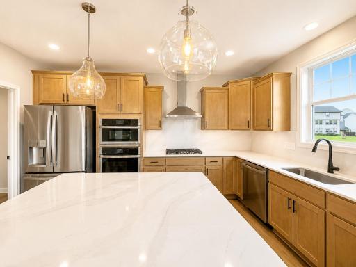 (Photo is of the actual home.) Designer-selected cabinets and quartz countertops frame the kitchen to provide cohesive style and functionality