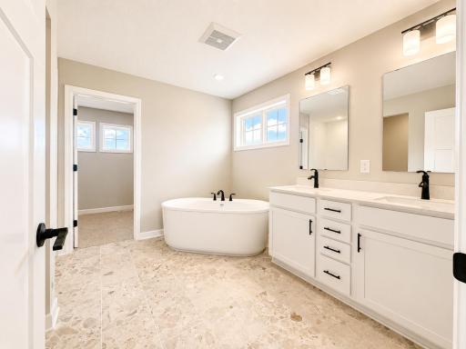 (Photo is of the actual home.) This elegant bathroom has direct access to the walk-in closet, perfect for getting ready throughout the week