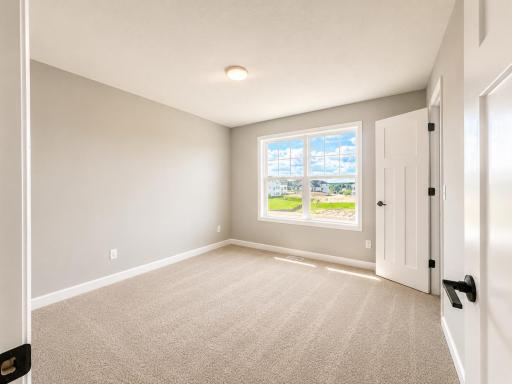 (Photo is of the actual home.) The secondary bedrooms provide spacious and private retreats for household members or overnight guests.