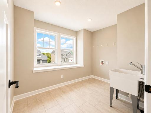 (Photo is of the actual home.) Located on the same floor as all the bedrooms is a spacious laundry room to conduct daily chores and organizational tasks. Comes with an included rinse sink.