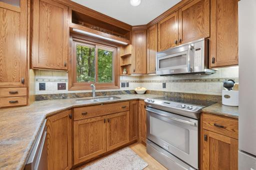 Multi-functional kitchen area with tiled backsplash and solid surface countertop.
