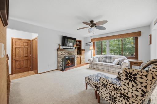 Main floor living room with a wood burning fireplace (storage for wood right next to it) - it also has a view out to the backyard.