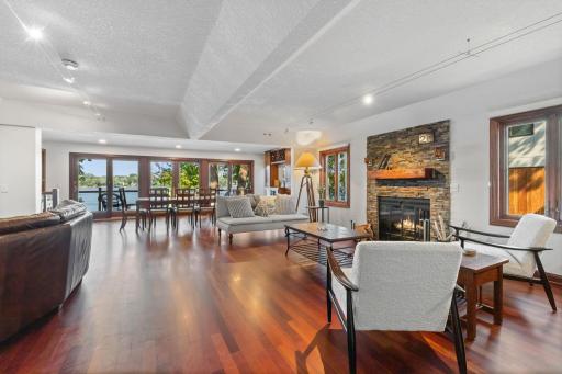 Sun-filled main level features an open-concept layout with three sets of sliding glass doors framing spectacular waterfront views.