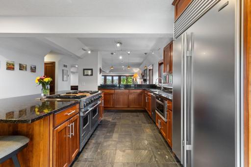 Custom wood cabinetry and granite countertops provide ample storage and workspace.
