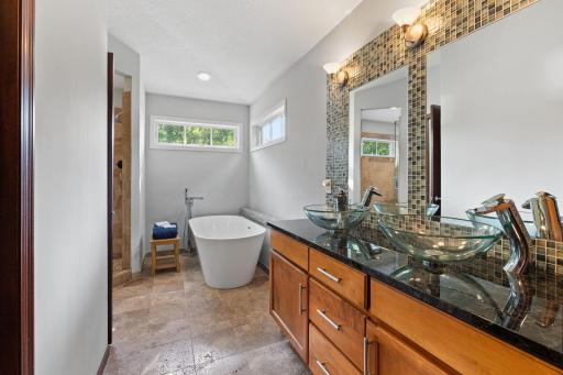 Private full primary bath features dual-sink vanity with stylish tile backsplash.
