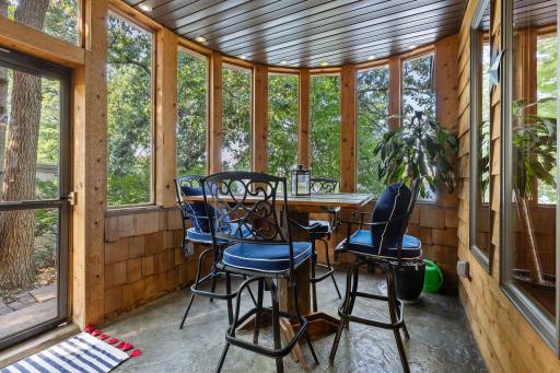 Enclosed porch offers sweeping semicircular views of the backyard and lake.