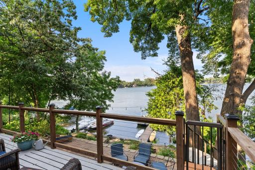 The main-level deck offers a relaxing outdoor seating area with a stairway leading directly down toward the waterfront