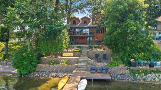 Beautiful lakefront living with a private dock, expansive deck, and thoughtfully landscaped tiered yard. Multiple outdoor seating areas provide plenty of space to relax and entertain while taking in the tranquil waterfront setting.