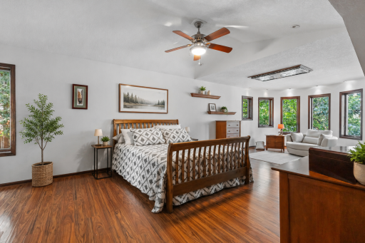 The spacious primary bedroom features an attached sitting area and large windows that flood the space with natural light.