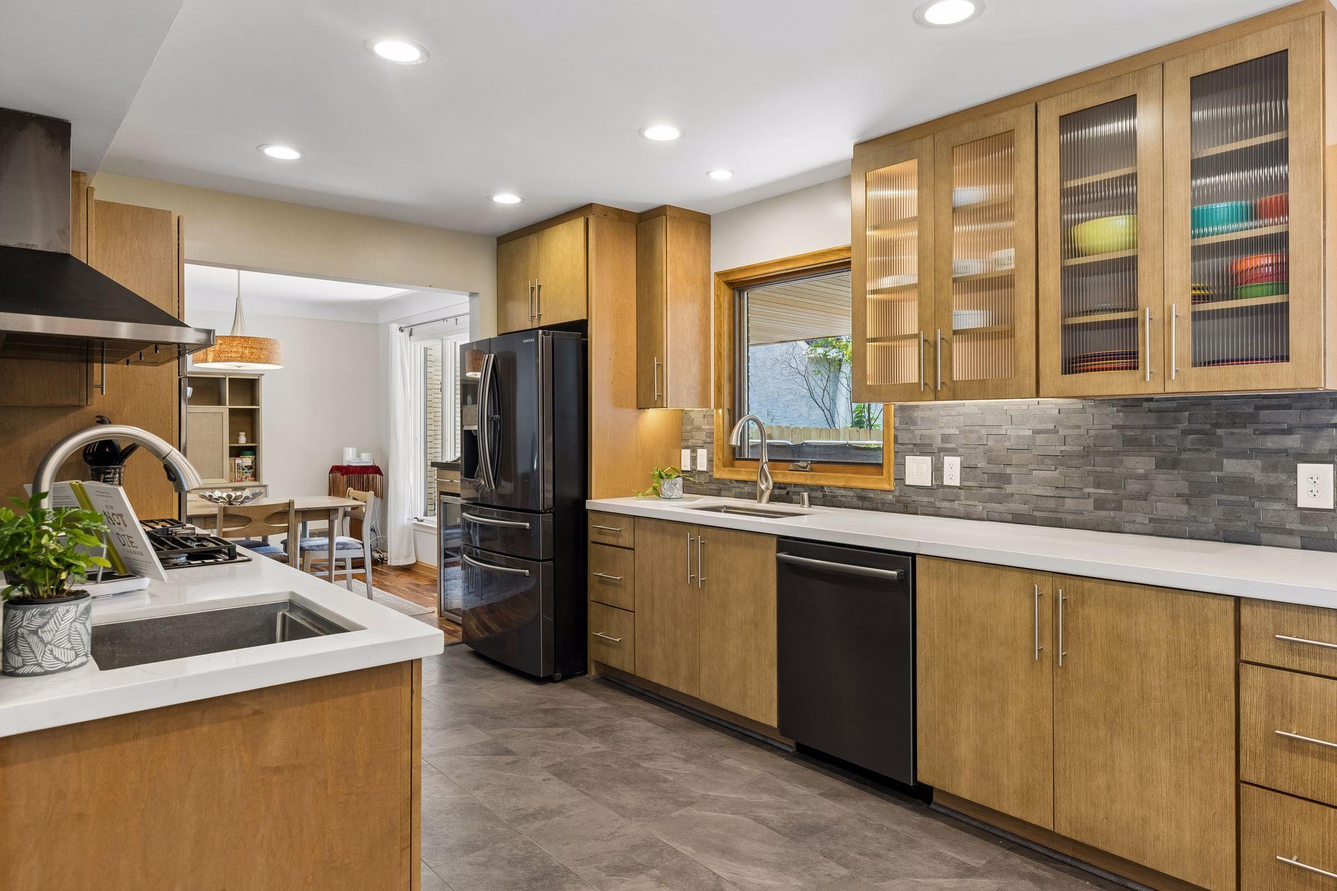 An oversized window floods the kitchen workspace with natural light, creating a bright and inviting space for everyday cooking and gathering.