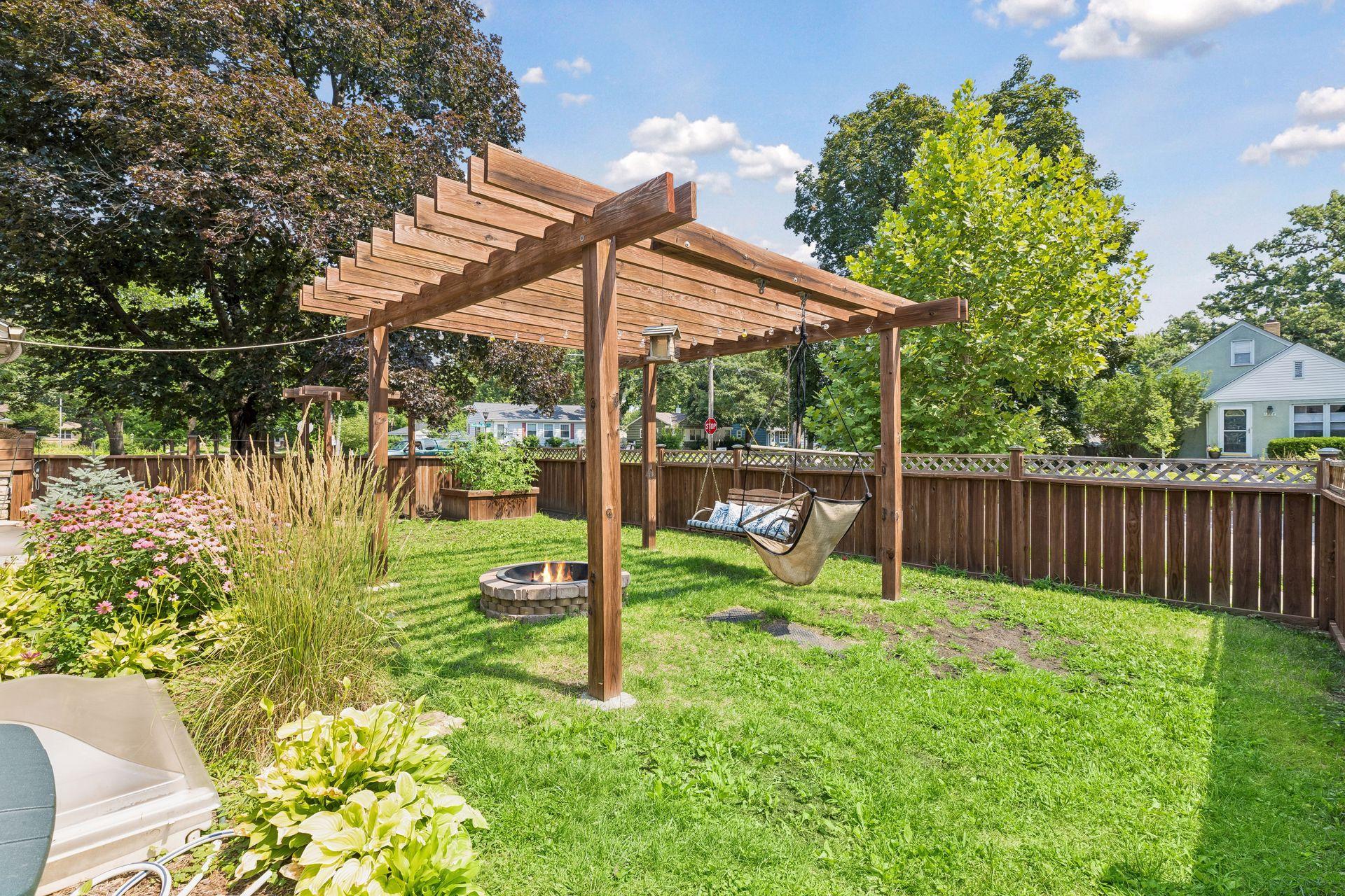 Private, fully fenced yard featuring a cozy firepit and pergola - an inviting space for relaxing and enjoying the outdoors.