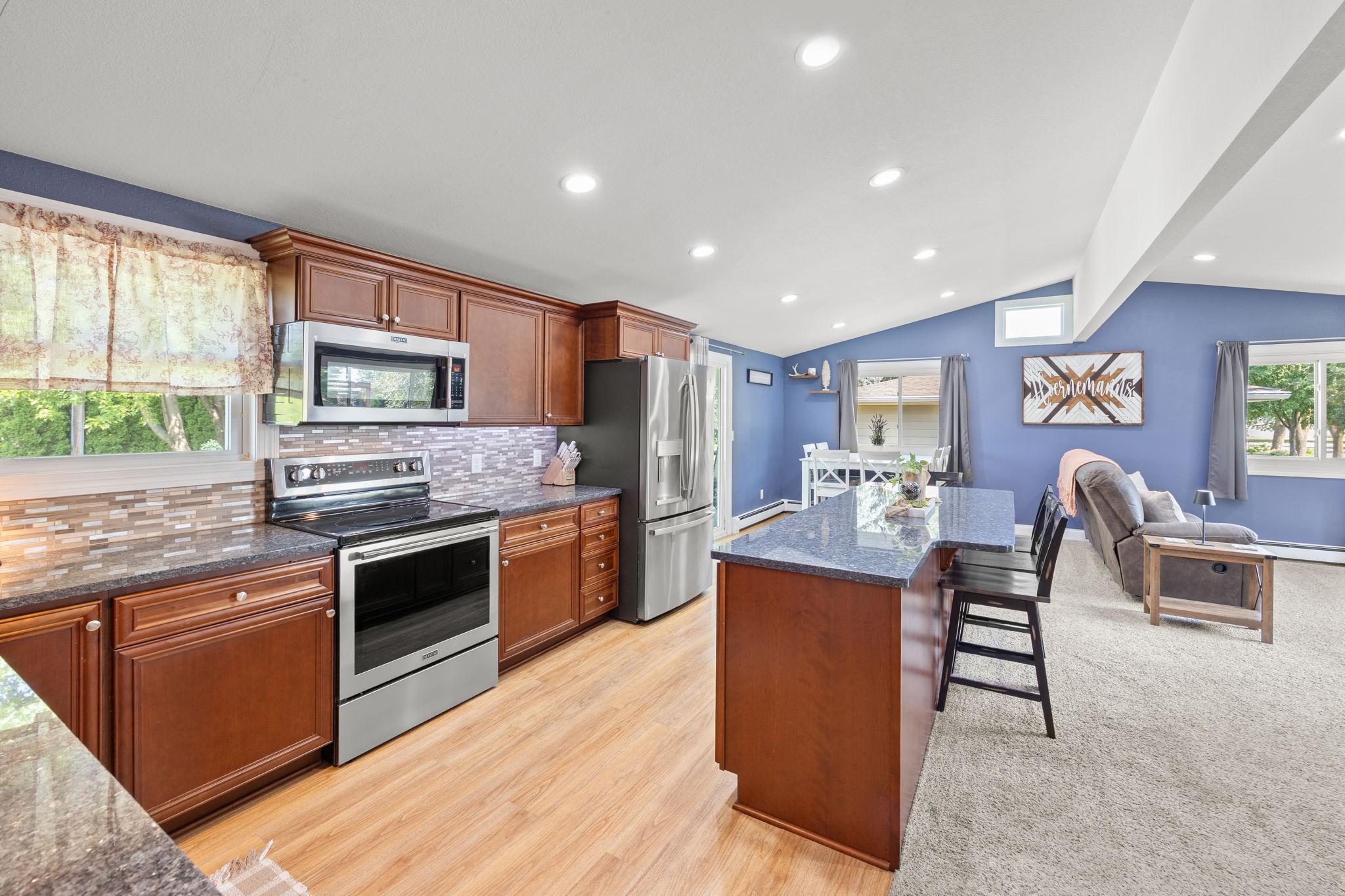 Spacious kitchen with stainless steel appliances, granite countertops and newer cabinets