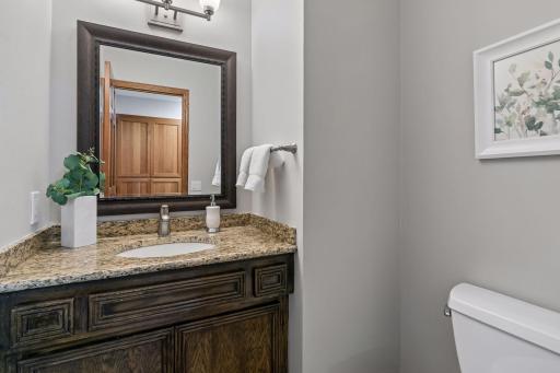 Updated half bathroom on the main level with granite countertops, mirror, faucet and fixtures.