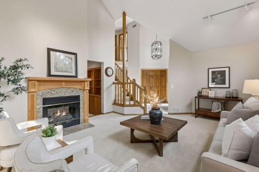 Upon entering the home you are greeted by this large living room with a two sided gas fireplace and vaulted ceilings. New light fixture was just added in the entryway.