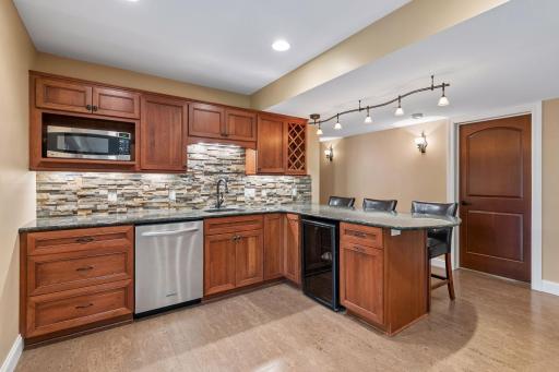 The wet bar features a tiled backsplash and lots of great accent lighting. This is a great space for multi-generational families.