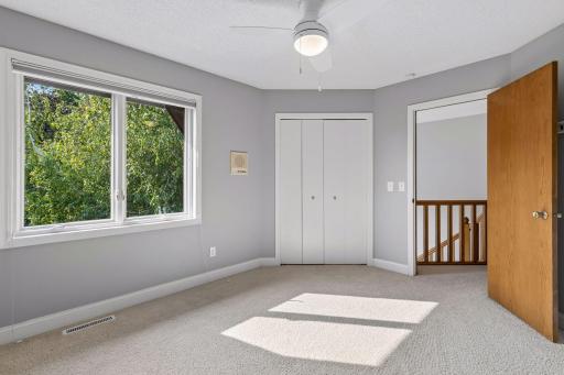 Bedroom #2 on the upper level with a ceiling fan.