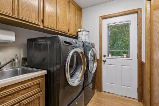 Another view of back area coming in from the garage. There's lots of storage and a utility sink and access to the back deck too. Washer and dryer stay with the home.