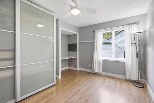 Bedroom #3 on the upper level with newer flooring and a ceiling fan. The IKEA closet can stay with the home.