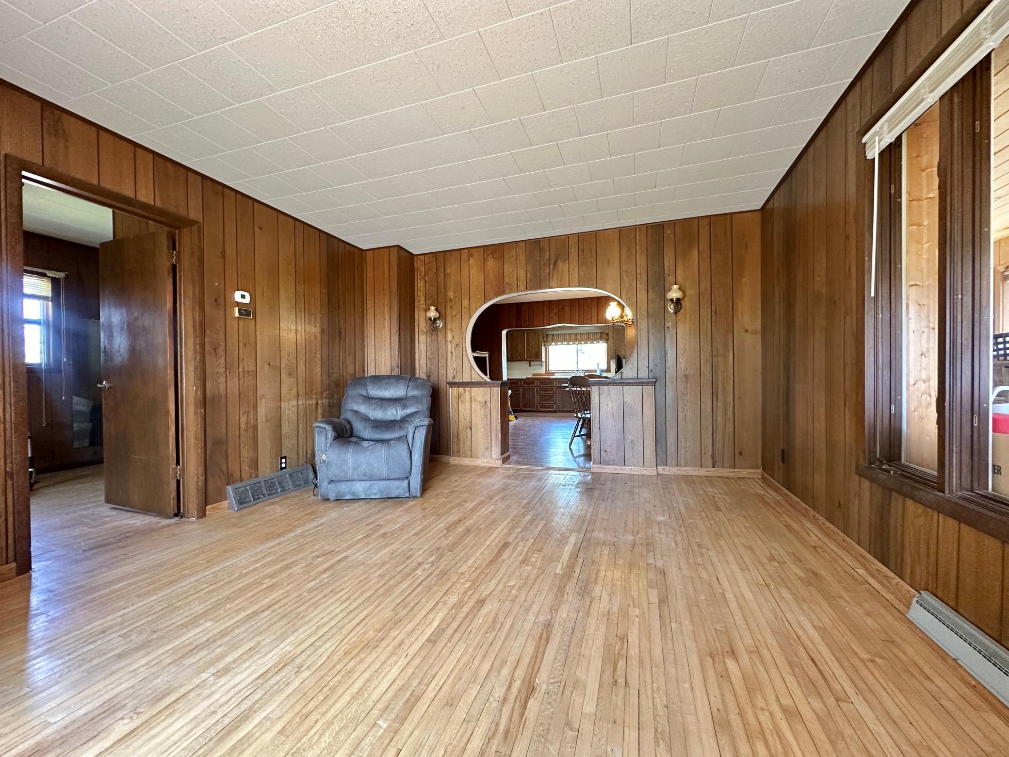 The living room is large with original wood floors you can see the dining and kitchen in the opening in back.