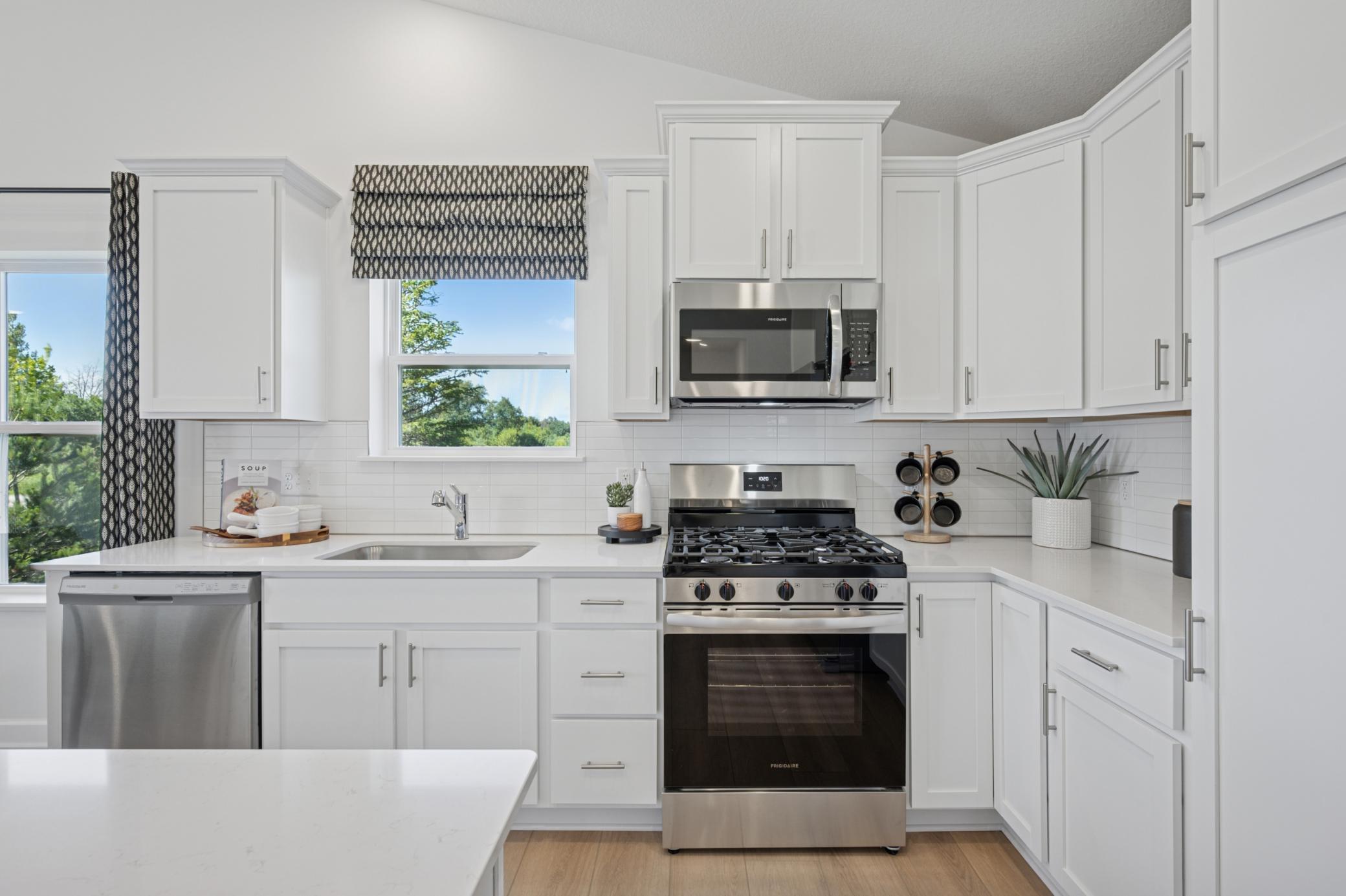 *Photo of model home, actual features may vary. This thoughtfully-designed kitchen layout features stainless steel appliances and quartz countertops.
