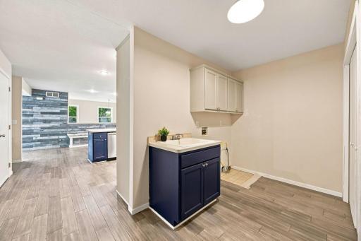 Main floor laundry with cupboard storage and drop in sink