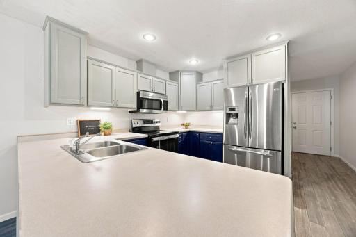 Beautiful kitchen with painted cabinetry, nice SS appliances, and an awesome breakfast counter with counter seating!
