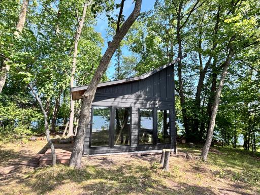 From the lake, it’s hard to see the structure, the black hides in the shadows while the windows reflect the lake as if you are seeing through to the lake on the other side of the island.