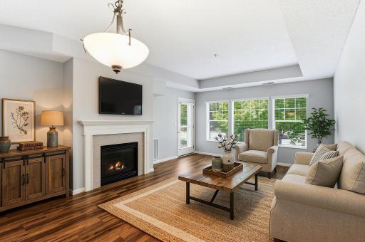 The attractive living area walks out to the large, covered deck. The windows have custom wood blinds. (Furniture and personal items are virtually staged.)