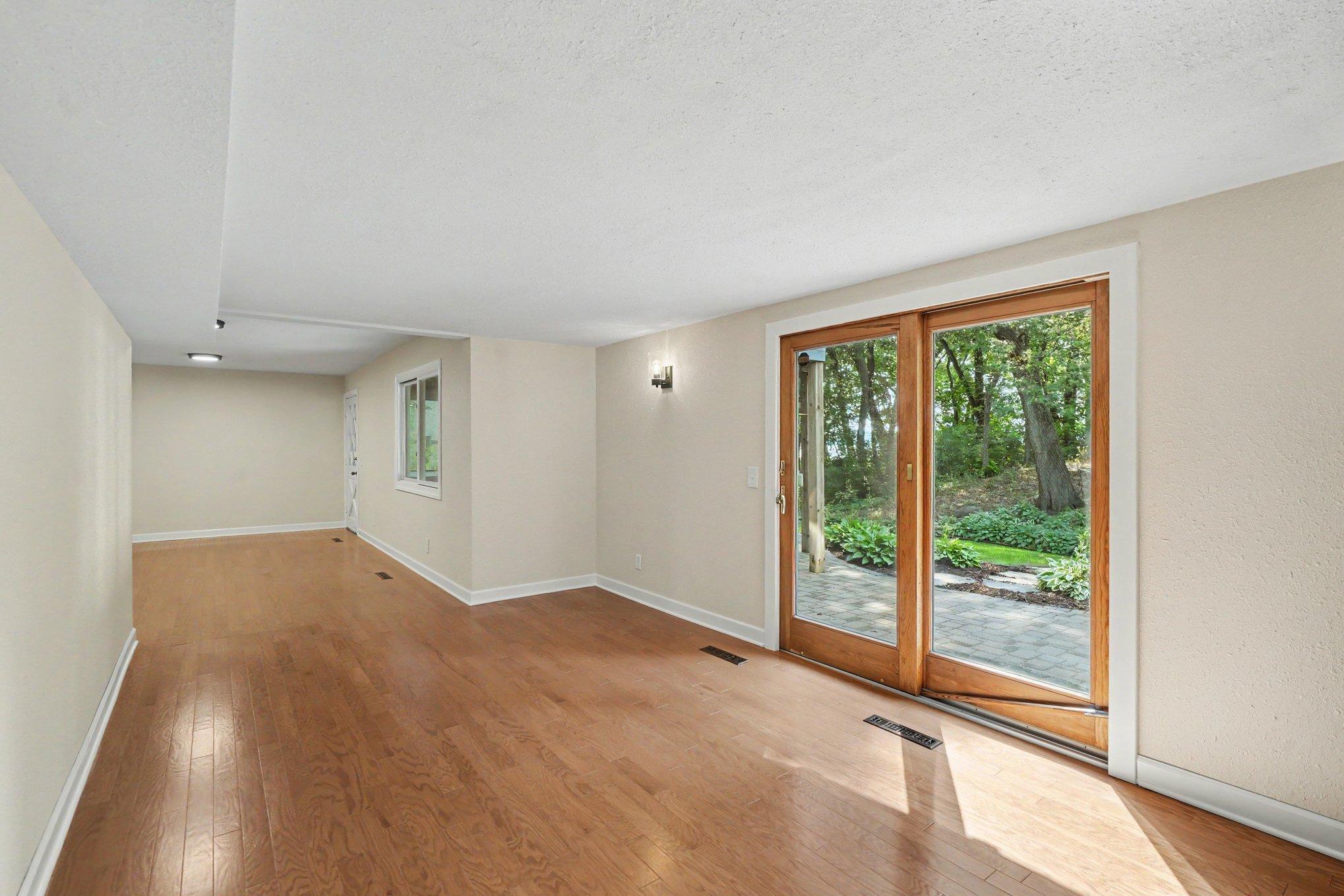 View from the fireplace into the family room and area for a game table. There is a door to access the backyard just past the window on the right.