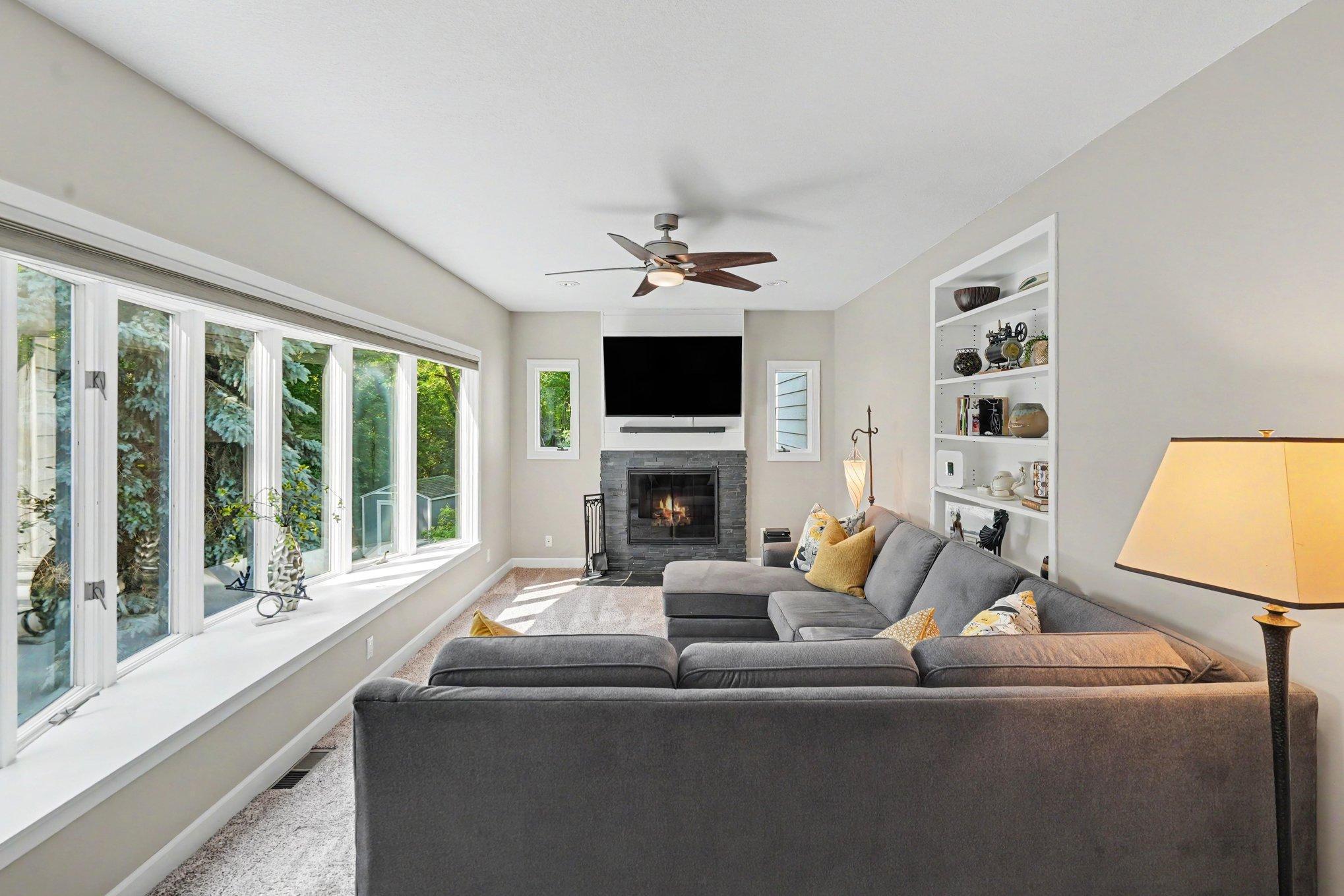 The living room has a bay window, woodburning fireplace and built-in shelving.